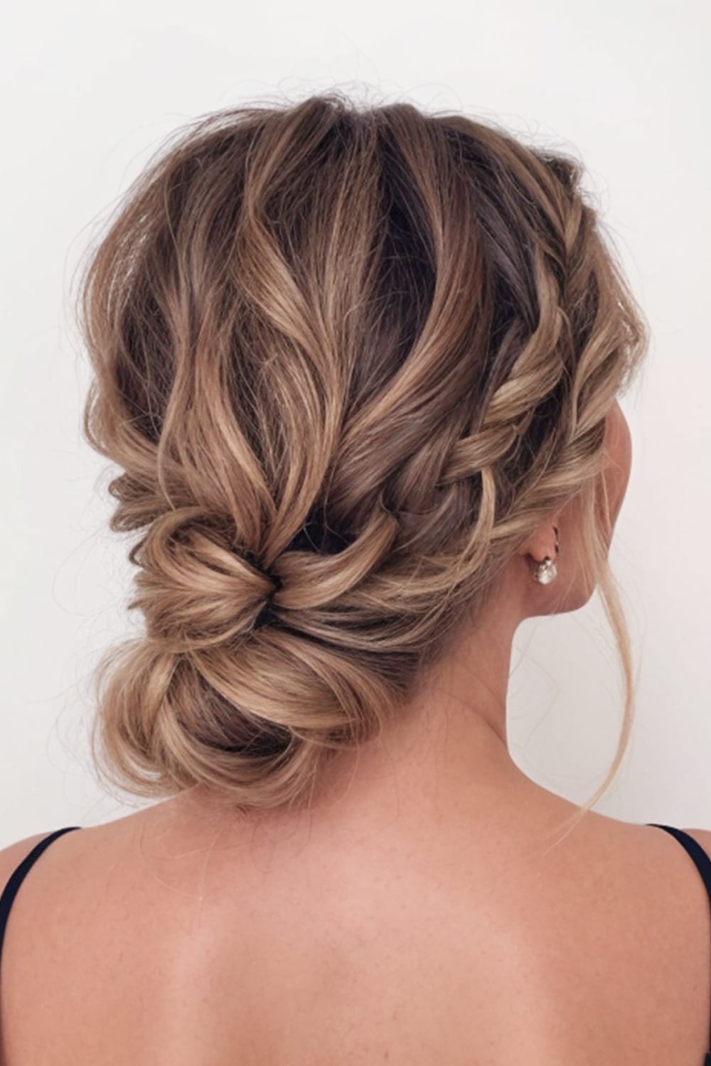 Low Curly Bun with Loose Strands copy